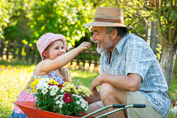 Happy grandfather with his granddaughter in the garden
